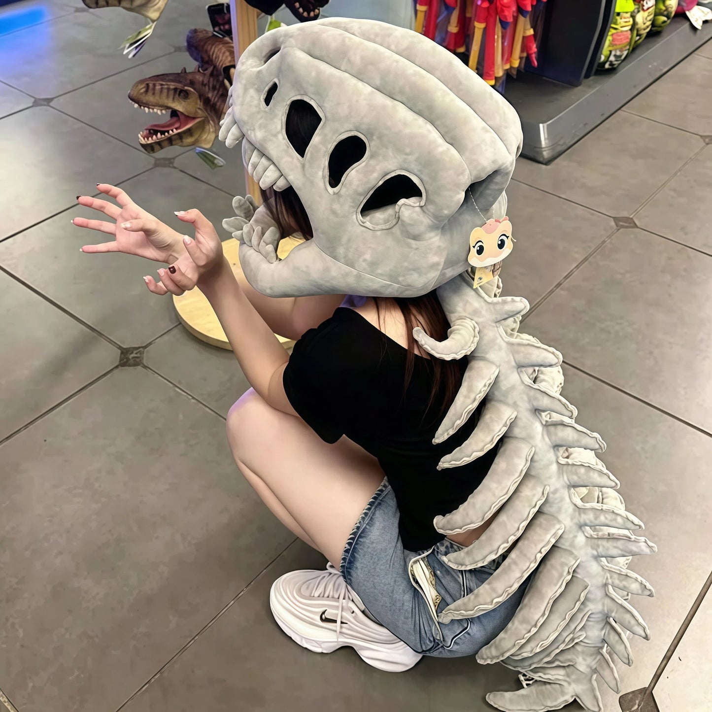 Oversized plush dinosaur costume hood displayed as funny gift idea for friends